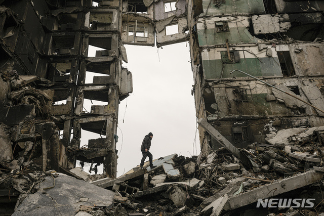 지난 5일(현지시간) 우크라이나 보로디얀카에서 한 주민이 우크라이나군과 러시아군의 교전 중 파괴된 아파트에서 소지품을 찾고 있다. (출처: 뉴시스)