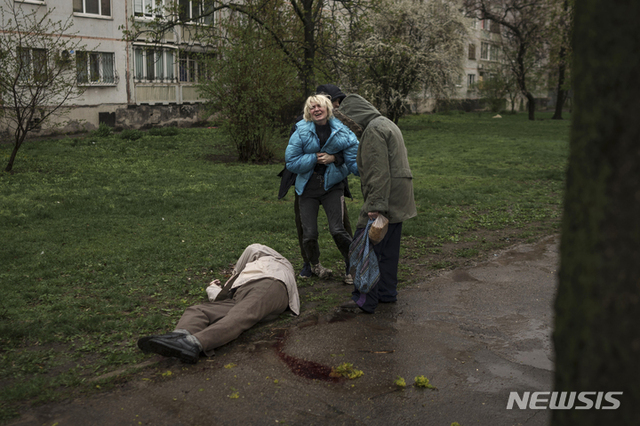 지난 18일(현지시간) 우크라이나 하르키우에서 한 여성이 러시아군의 공격을 받고 거리에 쓰러져 있는 아버지의 시신 옆에서 울고 있다. (출처: 뉴시스)