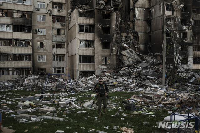 [하르키우=AP/뉴시스] 25일(현지시간) 우크라이나 하르키우에서 우크라인 군인이 러시아군의 여러 차례에 걸친 포격으로 심하게 파손된 건물 잔해를 살피고 있다.