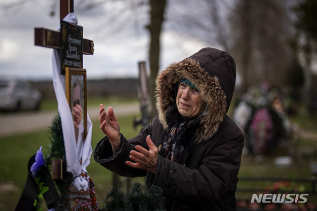 발렌티나 네치포렌코(77)가 지난 18일(현지시간) 우크라이나 수도 키이우 외곽 부차의 공동묘지에서 장례식을 치를 동안 아들 루슬란(47)을 애도하고 있다. 루슬란은 전날 부차 거리에서 이웃들에게 인도적 원조를 제공하던 중 러시아군에 살해 당했다. (출처: 뉴시스)