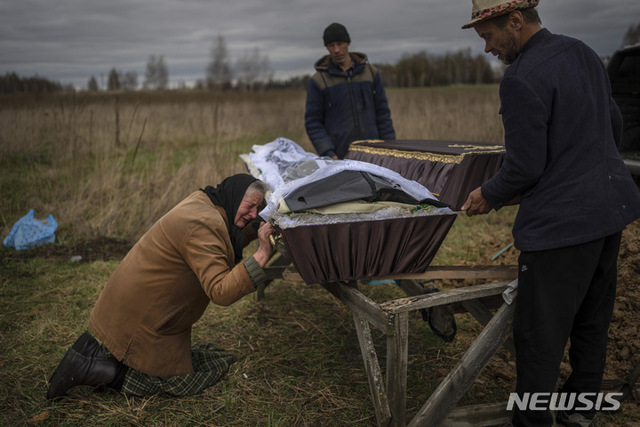나디야 트루브파니노바(70)가 지난달 30일 우크라이나 키이우 외곽 미쿨리치 묘지에서 러시아군에 살해된 아들 바딤(48)의 관을 안고 울고 있다. 바딤의 시신이 발견된 지 9일 후에야 나디야는 마침내 바딤의 장례식을 치를 수 있었다. 나디야는 아들의 시신을 매장하기 위해 산산조각이 난 부차 마을까지 히치하이킹을 할 수밖에 없었다. (출처: 뉴시스)