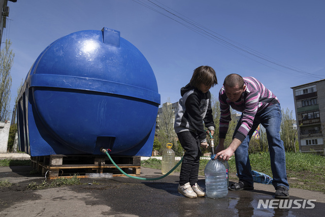 [토레츠크=AP/뉴시스] 25일(현지시간) 우크라이나 동부 도네츠크주 토레츠크 주민들이 물탱크에서 식수를 받고 있다. 토레츠크 주민들은 전쟁으로 두 달 이상 수도가 끊긴 채 지내고 있다.