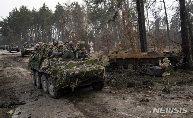 [키이우=AP/뉴시스] 3월 31일(현지시간) 우크라이나 키이우 외곽에서 우크라이나 군인들이 장갑차를 타고 파괴된 러시아 전차 옆을 지나고 있다.