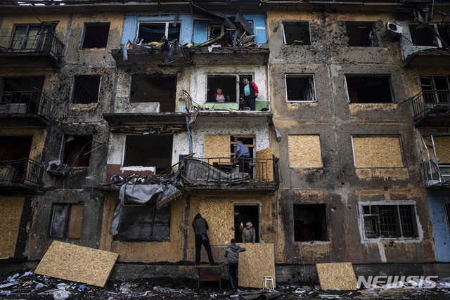 지난달 30일(현지시간) 우크라이나 동부 도네츠크 지역 도브로필랴에서 러시아군의 포격 이후 현지 주민들이 합판으로 아파트 창문을 닫고 있다. (출처: 뉴시스)