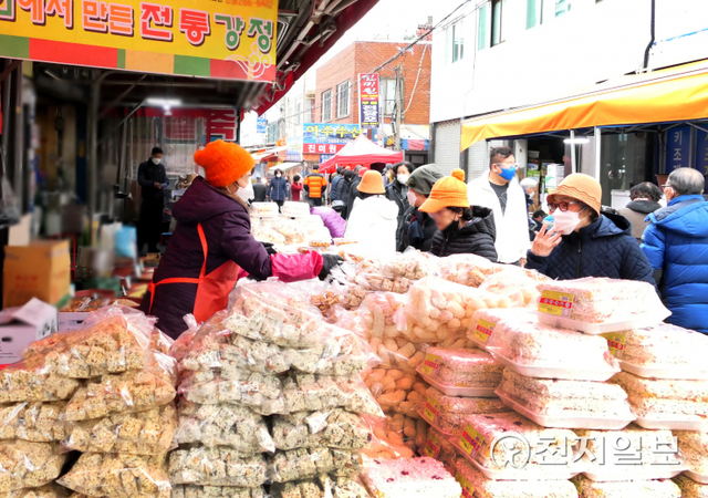 [천지일보 광주=이미애 기자] 민족 고유의 설 명절을 일주일 앞둔 24일 광주 북구 말바우 전통시장을 찾은 시민들이 전통방식으로 만들어진 강정과 유과를 살펴보고 있다. ⓒ천지일보 2022.1.27