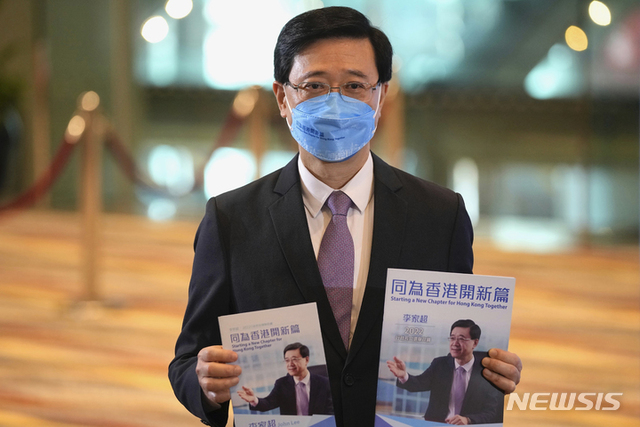 [홍콩=AP/뉴시스] 존 리 전 홍콩 정무부총리가 지난달 29일 홍콩에서 행정장관 선거 공약 기자회견 마친 후 홍보물을 들고 기자들 앞에서 포즈를 취하고 있다.