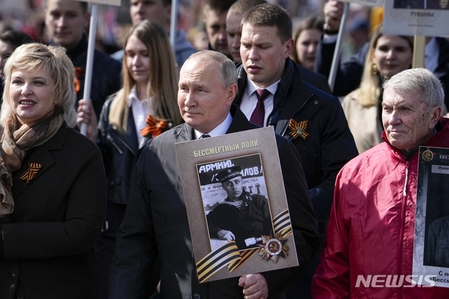 [모스크바=AP/뉴시스] 블라디미르 푸틴 러시아 대통령이 9일(현지시간) 러시아 모스크바의 붉은 광장에서 제2차 세계 대전 종전 제77주년(전승절) 열병식이 끝난 후 열린 '불멸의 연대' 행진에 2차 대전에 참전했던 선친 '스피리도노비치 푸틴'의 사진을 들고 행진하고 있다.