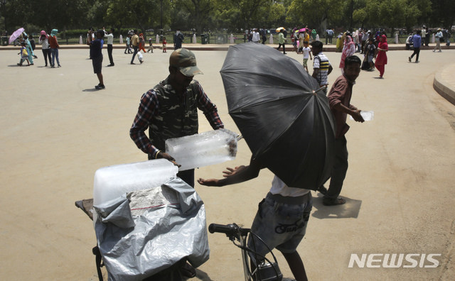 10일(현지시간) 인도 뉴델리 공원에서 한 남성이 가판대 주인에게 얼음을 팔고 있다.  인도 라자스탄주 일부 지역에서는 최고기온이 섭씨 48도까지 치솟는 등 극심한 폭염 상황이 인도 북부와 서부 지역을 휩쓸고 있다. (출처: 뉴시스)
