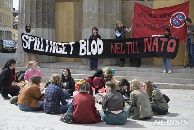 16일(현지시간) 스웨덴 스톡홀름 의회 밖에서 시위대가 “피를 흘리게 하는 나토는 안 된다”고 적힌 현수막을 들고 나토 가입 신청 반대를 외치고 있다. (출처: 뉴시스)