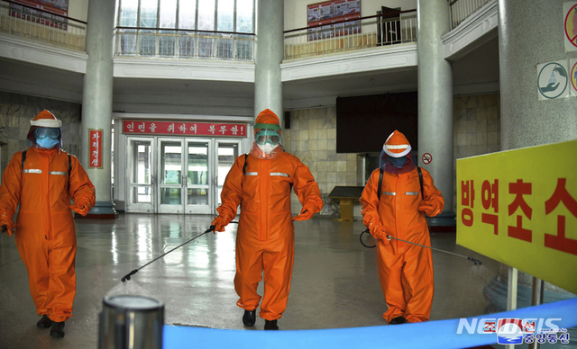 [평양=AP/뉴시스] 북한 조선중앙통신이 제공한 사진에 17일 평양역에서 역무원들이 코로나19 확산을 막기 위해 역 바닥을 소독하고 있다. 2022.05.18.