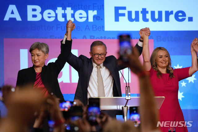 22일(현지시간) 호주 시드니에서 열린 노동당 행사에서 앤서니 알바니즈 노동당 대표(가운데)가 파트너 조디 헤이든(오른쪽)과 노동당 상원 원내대표인 페니 웡과 함께 손을 잡고 축하하고 있다. (출처: 뉴시스)