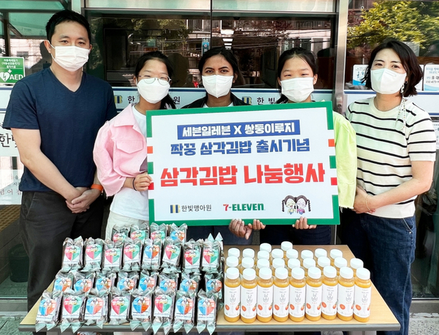 세븐일레븐이 지난 21일 인기 키즈 유튜버인 ‘쌍둥이 루지’와 서울 강북구 수유동 소재 한빛맹아원에 짝꿍삼각김밥과 음료수 등 먹거리를 전달하고 기념 사진을 촬영하고 있다. (제공: 세븐일레븐)