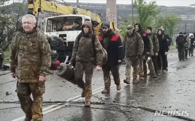 [마리우폴=AP/뉴시스] 19일(현지시간) 우크라이나 동부 도네츠크인민공화국(DPR) 산하 마리우폴의 아조우스탈 제철소에서 우크라이나 군인들이 걸어 나오고 있다.