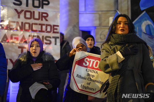 작년 12월 9일(현지시간) 영국 런던의 중국 대사관 앞에서 중국 정부의 위구르인 인권 침해를 항의하는 시위대가 플래카드와 깃발을 들고 구호를 외치고 있다. (출처: 뉴시스)