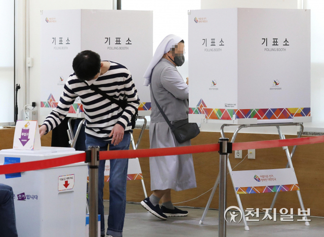 [천지일보=남승우 기자] 제8회 전국동시지방선거 사전투표가 시작된 27일 오전 서울 중구 중림동주민센터 사전투표소에서 한 수녀가 투표용지를 들고 기표소로 들어가고 있다. ⓒ천지일보 2022.5.27