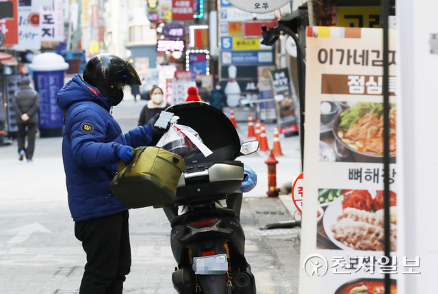[천지일보=남승우 기자] 사회적 거리두기 조정안 발표를 하루 앞둔 13일 서울 종로구 젊음의 거리에서 한 배달라이더가 포장 음식을 오토바이에 싣고 있다.오미크론 변이 등 코로나19 확산세가 좀처럼 누그러들지 않고 있어 정부는 현행 ‘사회적 거리두기’ 조치 2주 연장에 무게를 두고 있다. 사적모임 규모와 다중이용시설 운영시간을 제한하는 현행 조치가 큰 틀에서 유지될 것으로 보인다. 또 종료 시점이 설 연휴와 맞물려 있는 만큼 거리두기 연장 기간이 기존 2주보다 더 길어질 가능성도 있다. ⓒ천지일보 2022.1.13