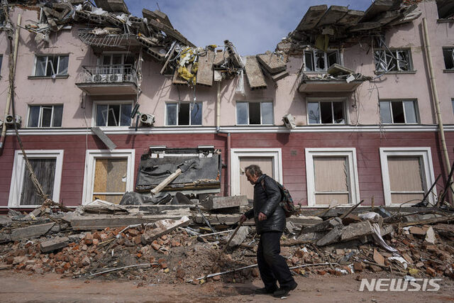 [체르니히우=AP/뉴시스] 지난 4월 7일(현지시간) 우크라이나 체르니히우에서 한 주민이 러시아군의 포격으로 파손된 아파트 건물 앞을 지나가고 있다.