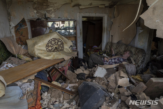 6일(현지시간) 우크라이나 동부 드루즈키우카에서 한 주민이 미사일 공격으로 파손된 자택의 소파에 앉아 쉬고 있다. (출처: 뉴시스)