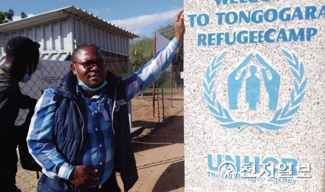 바이런 편집장은 평화를 위한 보도에 앞장서고 있다. 사진은 짐바브웨 남동쪽에 있는 통고가 지역의 유엔난민기구 난민캠프를 취재한 후 간판 앞에서 사진을 촬영하는 모습(왼쪽). (제공: HWPL) ⓒ천지일보 2022.6.21