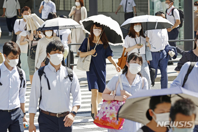 27일 일본 도쿄에서 양산을 든 사람들이 더위 속에 교차로를 건너고 있다. (출처: 뉴시스)