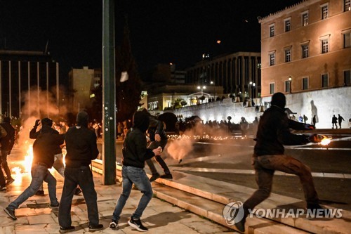 지난 3일(현지시간) 아테네의 그리스 의회 앞에서 시위에 나선 청년들이 화염병을 던지고 있다. (출처: AFP, 연합뉴스)