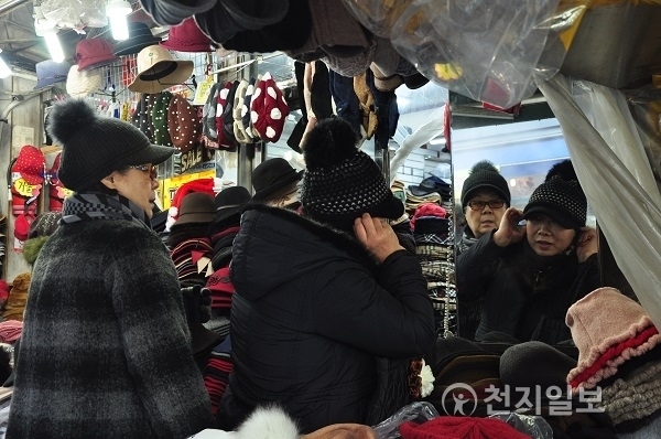 서울 중구 남대문시장에서 한 시민이 겨울용 모자를 고르고 있다. ⓒ천지일보DB