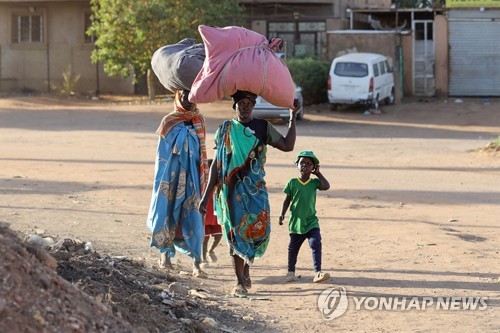 19일 수단 하르툼에서 군벌끼리 무력 충돌이 이어지자 주민들이 자녀와 함께 피신하고 있다. (AFP/뉴시스)