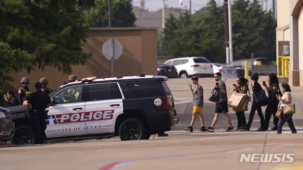 [앨런=AP/뉴시스] 6일(현지시간) 미국 텍사스주 외곽 앨런의 한 대형 쇼핑몰에서 총기난사 사건이 발생한 뒤 쇼핑몰을 나서는 사람들이 손을 들고 걸어 나오고 있다.
