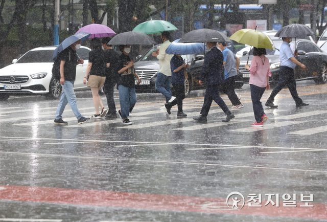 소나기가 오는 가운데 시민들이 우산을 쓰고 횡단보도를 건너고 있다. ⓒ천지일보DB
