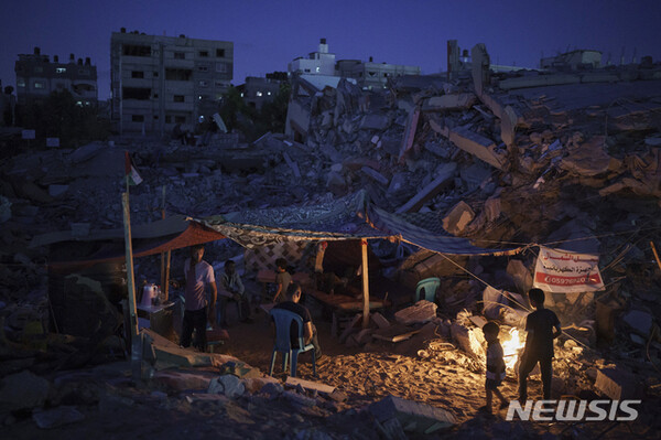 지난 4일 팔레스타인 가자지구 북부 베이트 라히아에서 주민들이 공습으로 파괴된 주택 잔해 사이에 지어진 텐트 안에 모여 있다. (출처: 뉴시스)
