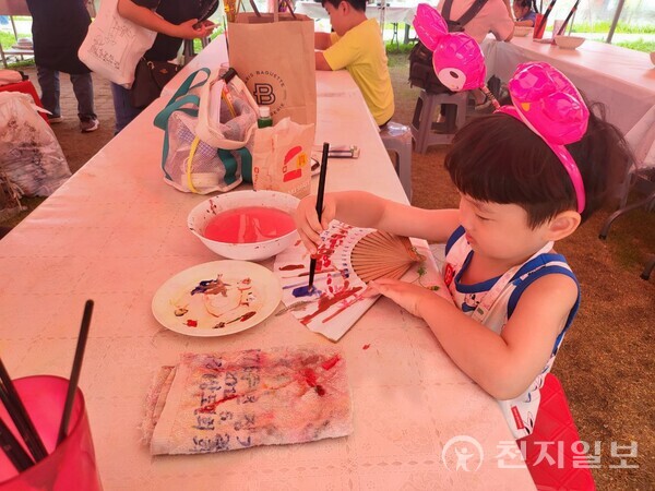 2023 강릉단오제를 구경나온 어린이가 단오부채에 그림을 그리고 있다. ⓒ천지일보 2023.06.25.
