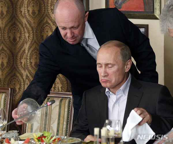 지난 2011년 11월 11일(현지시각) 모스크바 외곽의 한 식당에서 저녁 식사 중 바그너 그룹 수장 예브게니 프리고진(왼쪽)이 블라디미르 푸틴 러시아 대통령에게 음식을 건네고 있는 모습. (AP/뉴시스)