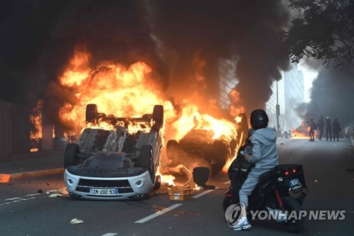 지난달 29일(현지시간) 프랑스 낭테르에서 일어난 10대 총격사망 항의 시위 도중 차량이 뒤집힌 채 불타고 있다. (AFP/연합뉴스)