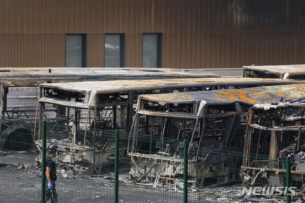 파리 외곽 오베르비리에의 바스 차고지에서 경찰 수사관들이 사흘째 이어진 29일 밤(현지시간) 폭력 시위로 불탄 버스들을 바라보고 있다. (AP/뉴시스)