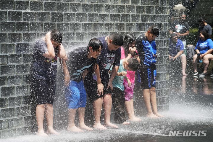 3일(현지시각) 미국 일리노이주 시카고 밀레니엄 파크의 분수대에서 어린이들이 물을 맞으며 더위를 식히고 있다. (AP/뉴시스)