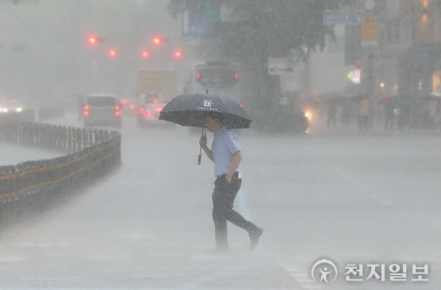 [천지일보=남승우 기자] 서울 종로구 광화문 네거리에서 시민들이 우산을 쓴 채 발걸음을 재촉하고 있다. ⓒ천지일보DB