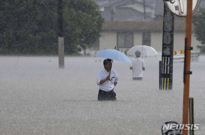 10일 일본 남부 후쿠오카현 구루메시에서 폭우 속에 사람들이 거리를 걷고 있다.(AP/뉴시스)