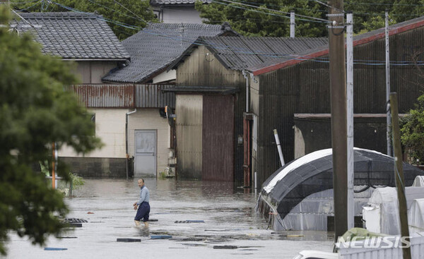 10일 일본 남부 후쿠오카현 구루메에서 한 남성이 폭우로 침수된 도로를 힘겹게 지나고 있다. 일본 남서부 지역에 폭우가 쏟아지면서 홍수와 산사태가 발생했으며 일본 기상청은 규슈 남부 일부 지역에 호우경보를 발령했다. 2023.07.10. (AP/뉴시스)