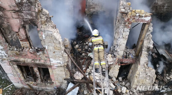 20일(현지시각) 우크라이나 남부 미콜라이우에서 소방관이 러시아군 공격으로 파괴된 주택가 화재를 진압하고 있다. (AP/뉴시스)