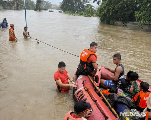 [바카라=AP/뉴시스] 26일(현지시각) 필리핀 북부 바카라에서 구조대가 태풍 독수리로 인한 홍수 피해 지역 주민들을 고지대로 이동시키고 있다. 필리핀 북부를 강타한 제5호 태풍 독수리의 여파로 저지대 마을에서 홍수가 발생하고 정전 등이 빚어졌으며 1만2천여 명의 이재민이 발생했다. 2023.07.26.