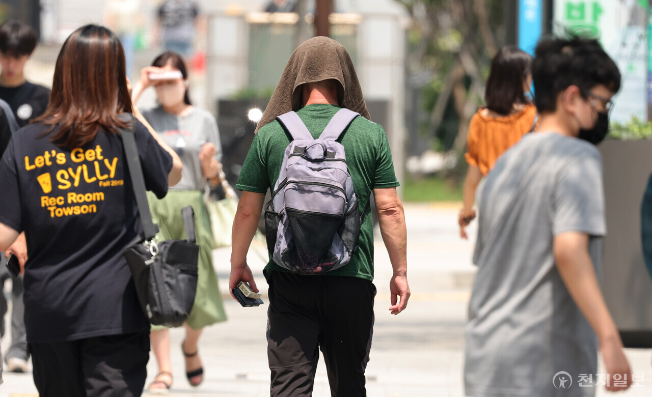 [천지일보=박준성 기자] 체감온도 35도 이상 치솟은 29일 서울 시내를 걸어가는 한 시민이 얼굴을 손수건으로 감싼 채 더위를 피하기 위해 애를 쓰고 있다. 기상청에 따르면 이날 오전 10시를 기해 서울 전역을 포함한 전국 대부분 지역에 폭염경보가 발표됐다. ⓒ천지일보 2023.07.29.