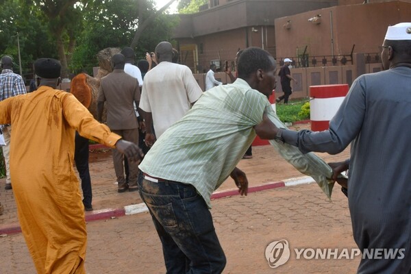 26일(현지시간) 서아프리카 니제르 수도 니아메에서 쿠데타 세력에 반대하는 시위를 벌이던 시민들이 위협사격에 달아나고 있다. (AFP/연합뉴스)
