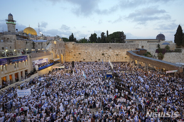 이스라엘 사람들이 18일(현지시각) 예루살렘 구시가지에서 가장 신성한 장소인 통곡의 벽 주변에 모여 국기를 들고 '예루살렘의 날'을 기념하고 있다. 이날 수천 명의 이스라엘 사람이 1967년 이스라엘이 중동 전쟁에서 동예루살렘을 점령한 '예루살렘의 날'을 기념해 국기 행진을 펼쳤다. (출처: AP/뉴시스)