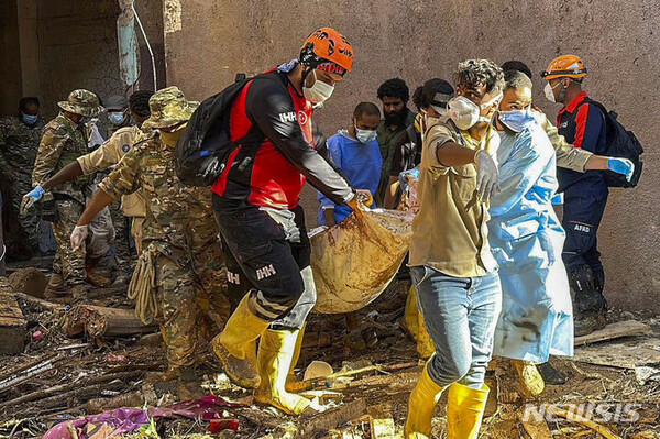 [데르나=AP/뉴시스] 튀르키예 인권 단체가 제공한 사진에 14일(현지시각) 리비아 데르나에서 구조대가 홍수 희생자 시신을 수습하고 있다. 리비아 적신월사는 수색 작업이 계속되면서 데르나 홍수 사망자 수가 약 1만3000명으로 급증했다고 밝혔다.