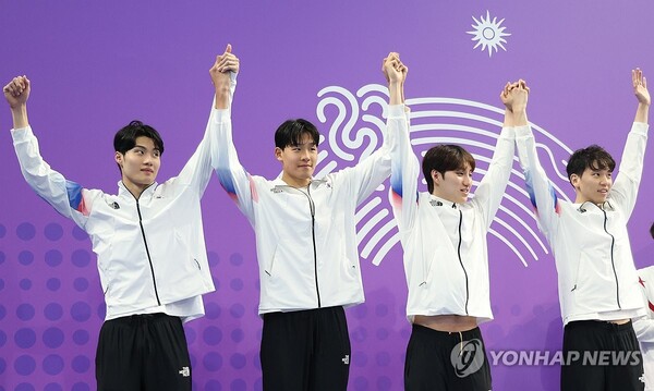 26일 중국 항저우 올림픽 스포츠센터 수영장에서 열린 2022 항저우 아시안게임 수영 남자 혼계영 400m 결승에서 은메달을 획득한 대한민국 선수들이 시상대에 오르며 팔을 들어 인사하고 있다. 한국 대표팀은 3분32초05로 한국신기록을 세웠다. (출처: 연합뉴스)