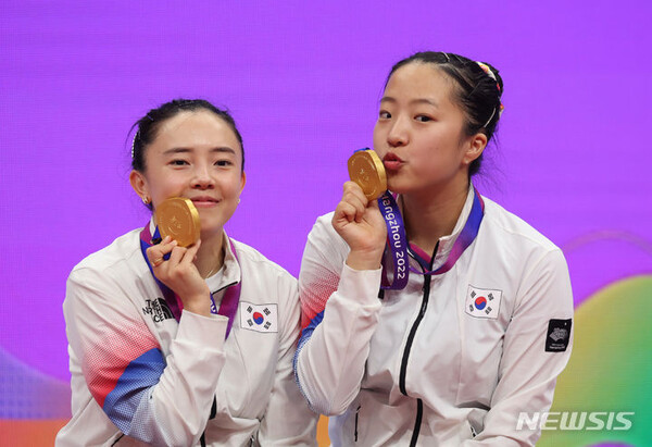 [항저우=뉴시스] 2일 중국 항저우 공슈 캐널 스포츠파크 짐내시움에서 열린 2022 항저우 아시안게임 여자 탁구 복식 결승 한국 대 북한 경기, 세트스코어 4:1로 북한에 승리를 거두고 금메달을 획득한 전지희, 신유빈이 시상식 후 금메달을 들고 포즈를 취하고 있다. 2023.10.02.