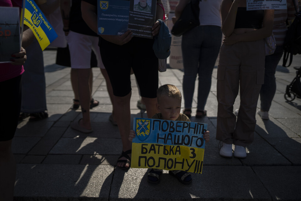 우크라이나 키이우 독립광장에서 열린 시위에서 포로로 잡힌 한 군인의 아들이 '아버지를 풀어주세요'라고 쓰인 현수막을 들고 있다. 이 시위는 우크라이나 군인들이 마리우폴 도시에서 러시아군에 의해 포로로 잡힌 지 500일을 맞아 열렸다. (AP/연합뉴스) 2023.08.28.