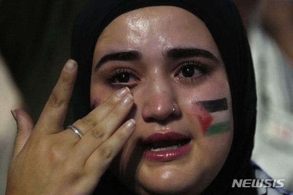 [마드리드=AP/뉴시스] 9일(현지시간) 스페인 마드리드에서 얼굴에 팔레스타인 깃발을 그린 여성이 이스라엘의 가자지구 공습에 반대하는 시위 도중 눈물을 흘리고 있다. 2023.10.10.