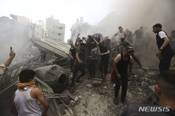 [가자지구=AP/뉴시스] 9일(현지시간) 가자지구 팔레스타인 주민들이 이스라엘의 공격으로 파괴된 건물 잔해에서 희생자 시신을 수습하고 있다. 2023.10.10.