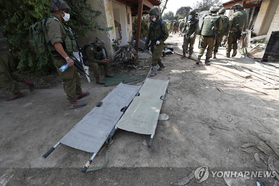 이스라엘 군인들이 10일(현지시간) 팔레스타인 가자지구 인근에 있는 크파르 아자 키부츠에서 살해된 이스라엘인들의 시신을 수습하는 작업을 하고 있다. (EPA/연합뉴스) 2023.10.11.
